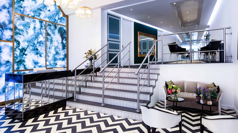 10 Brick Street's staircase, grand piano and plush green sofa