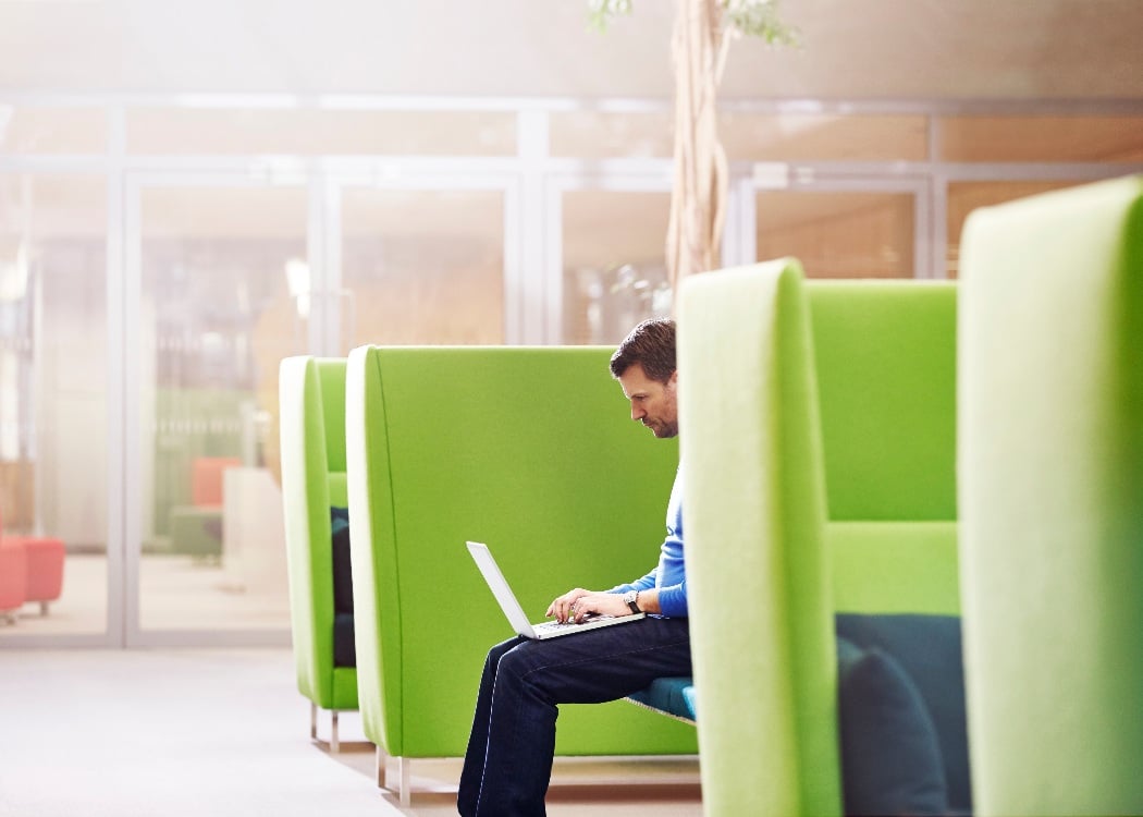 Business person working in a booth in a modern office