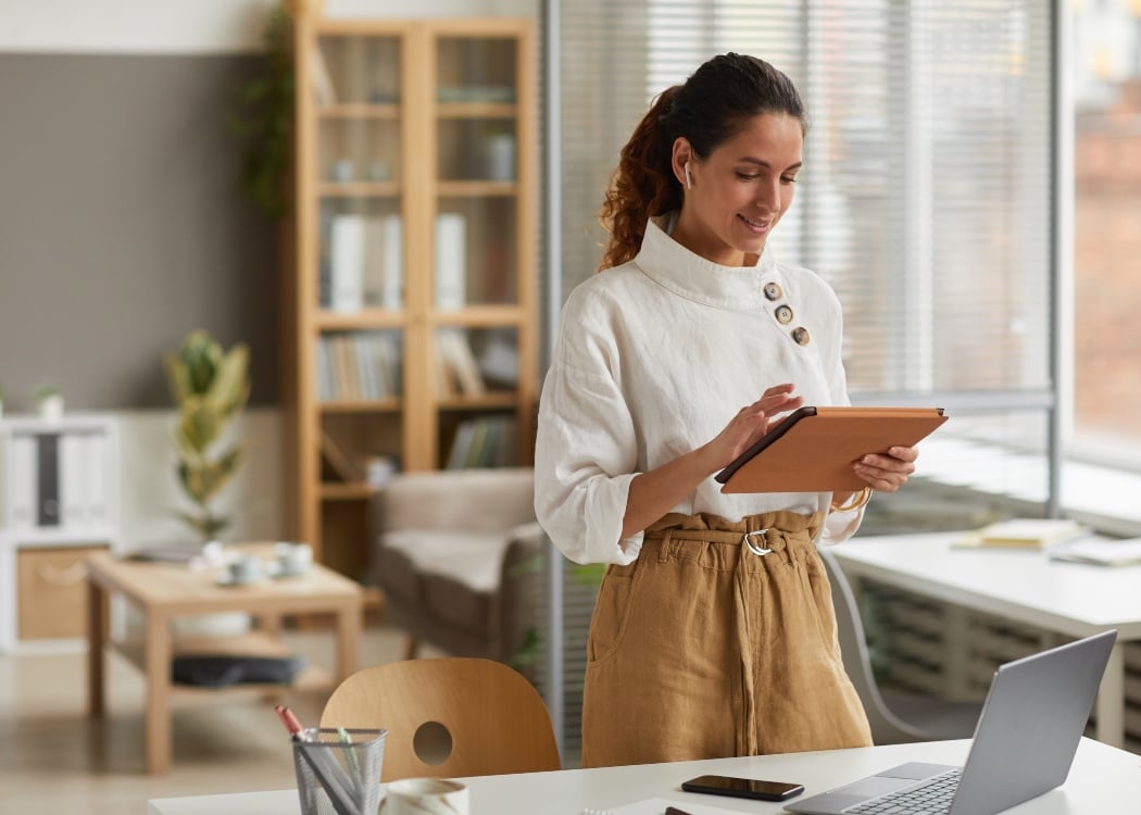 A woman in the office looking at an ipad